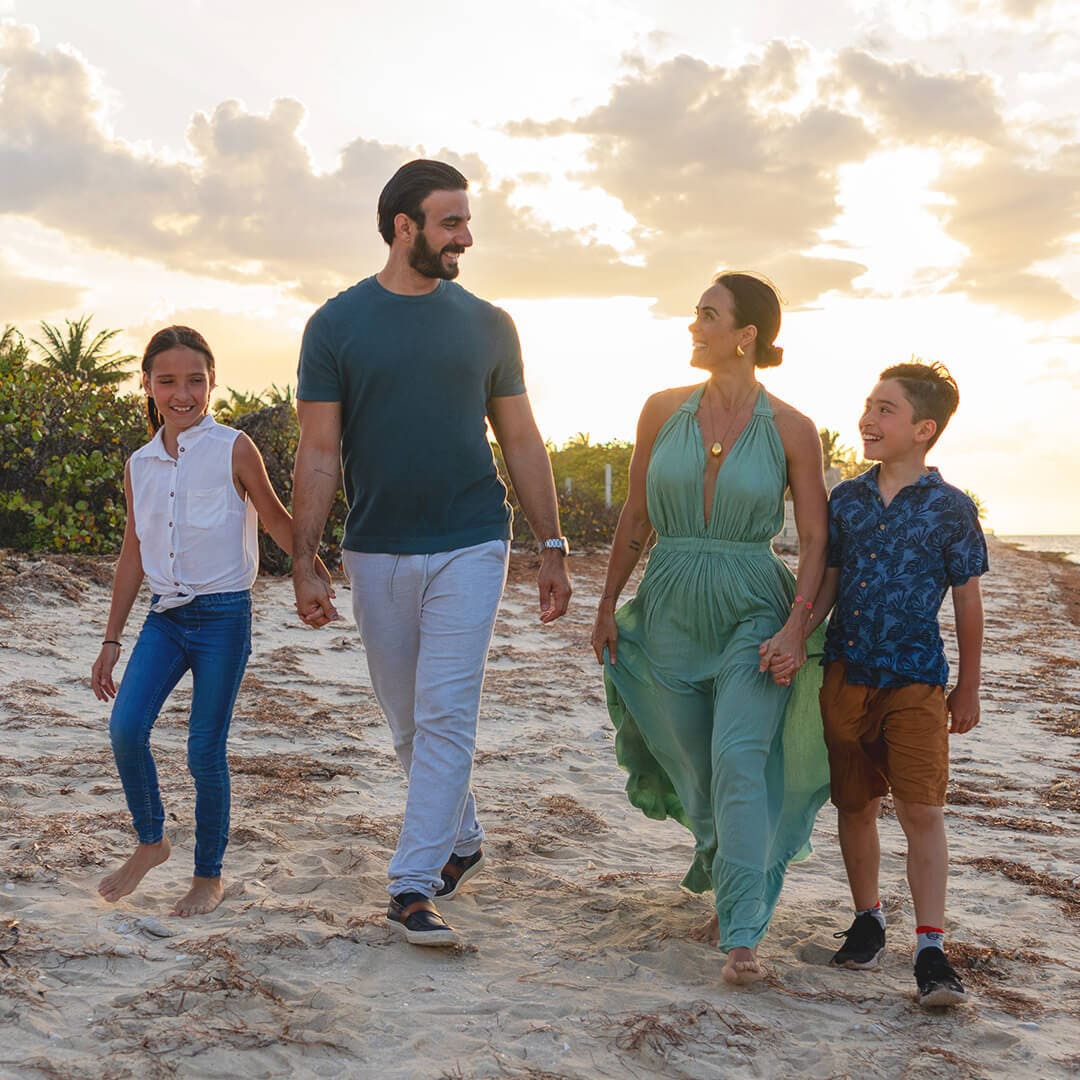 Familia caminando por la playa de San Crisanto al atardecer